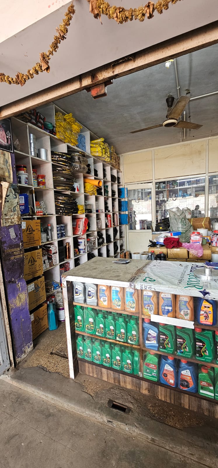 Shop counter with oils and pigeonhole shelves of belts and spares